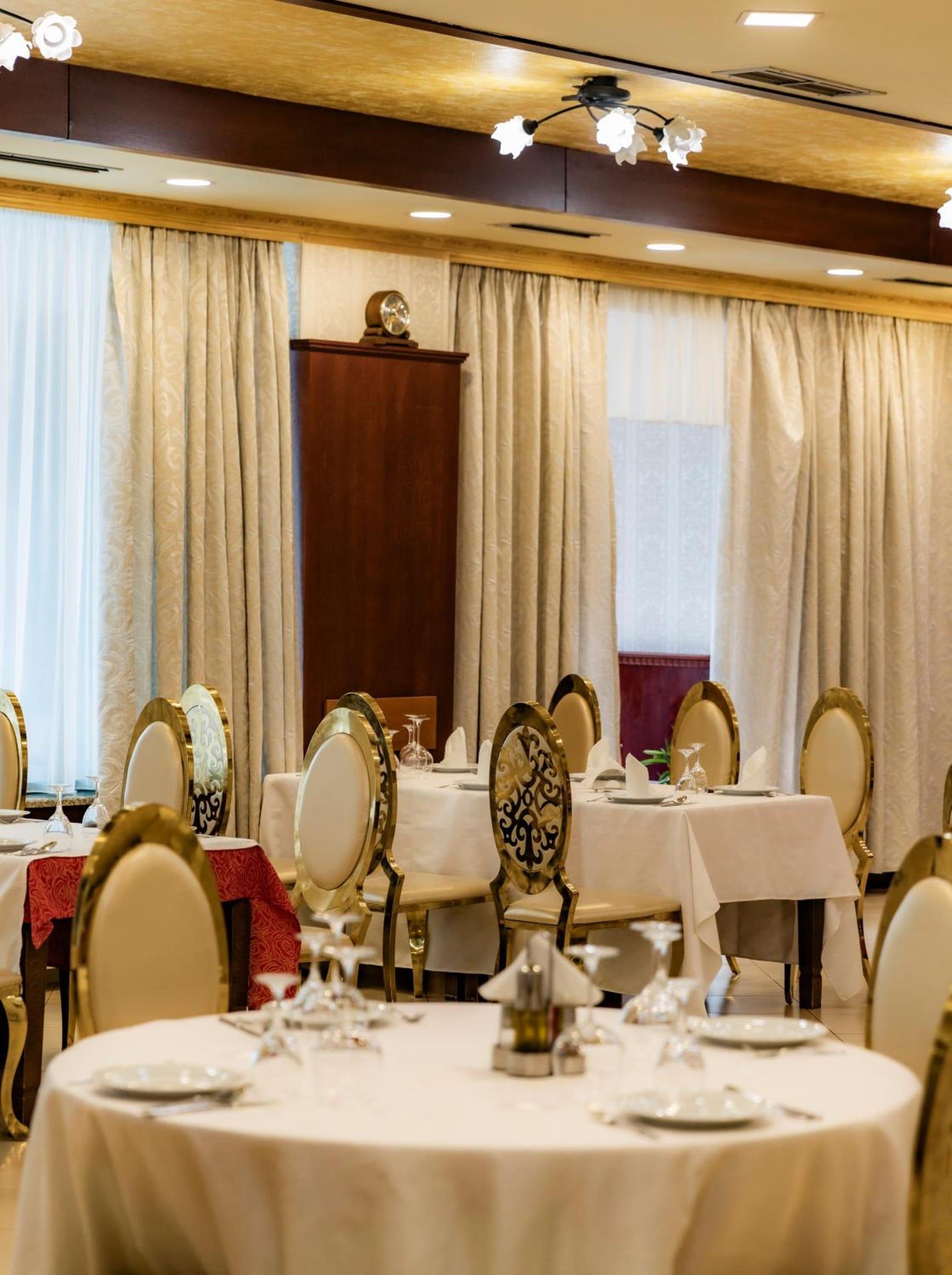 Set tables in the restaurant beside windows with light curtains